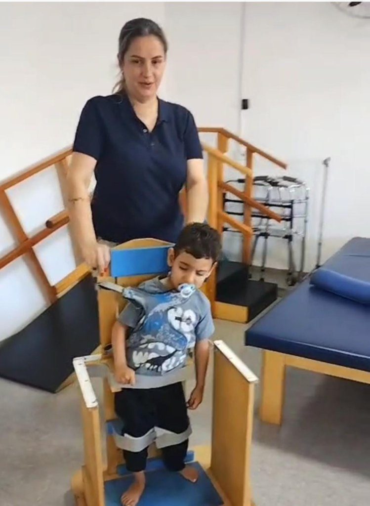 Sessão de reabilitação física com criança em barras paralelas